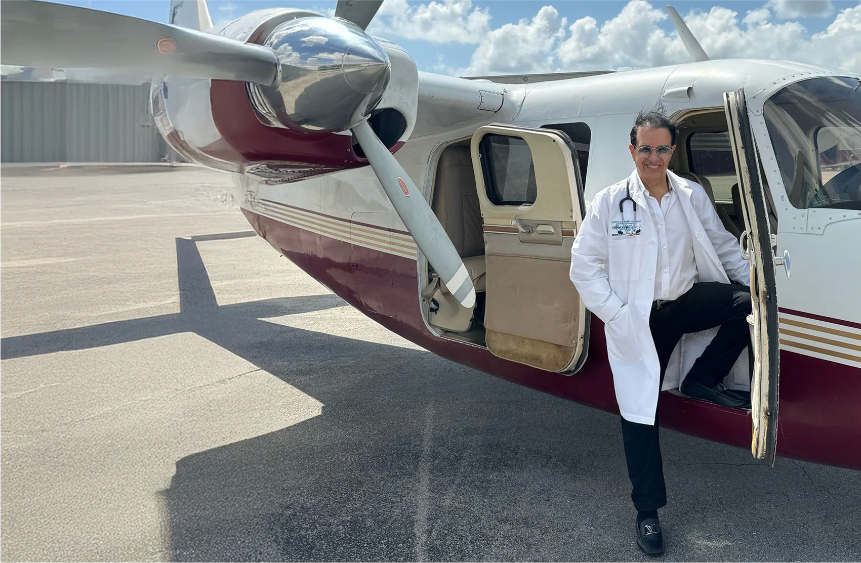 Dr. Phanor Calle, FAA Aviation Medical Examiner in Weston, Florida, standing beside an aircraft on the runway.