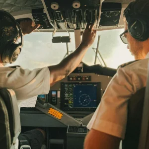 Two pilots inside an airplane cockpit during pre-flight checks, representing FAA medical exams for pilots at Weston Medical Clinic.