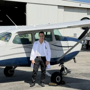 Dr. Phanor Calle, Senior FAA Aviation Medical Examiner, standing beside an aircraft at an airport for FAA aviation medical exams in Weston, Florida.